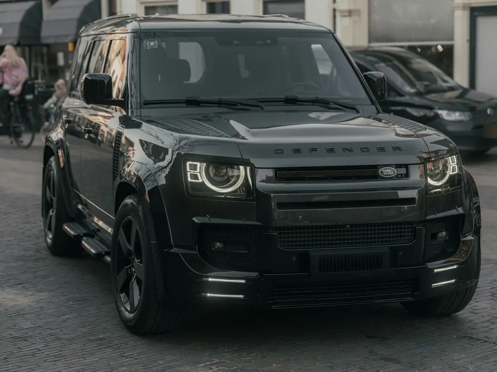Black Land Rover Defender parked on a street